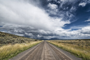 Empty road amidst field against cloudy sky - CAVF15129