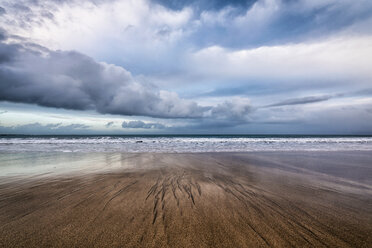 Landschaftlicher Blick auf Wellen, die am Strand gegen einen bewölkten Himmel ans Ufer rauschen - CAVF15161