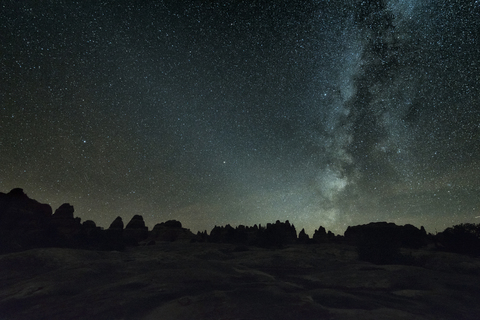 Silhouette Landschaft gegen Sternenfeld bei Nacht, lizenzfreies Stockfoto