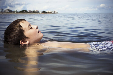 Hemdloser Junge schwimmt auf dem Meer während eines sonnigen Tages - CAVF15208