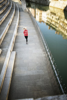 Hohe Winkel Ansicht der sportlichen Frau läuft auf Gehweg am Fluss - CAVF15227