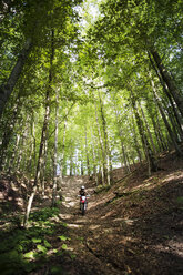 Motorradfahrerin fährt im Wald - CAVF15237