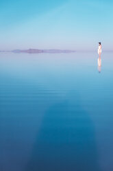 Fernblick auf eine im See stehende Frau in den Bonneville Salt Flats - CAVF15240