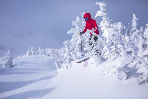 Frau beim Skifahren auf verschneitem Feld, lizenzfreies Stockfoto