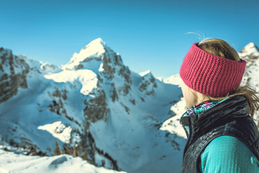 Side view of woman standing against snowcapped mountains - CAVF15267