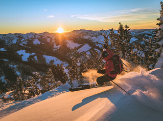 Frau beim Skifahren auf einer Schneepiste bei Sonnenuntergang - CAVF15273