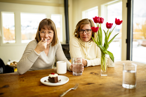 Porträt von am Tisch sitzenden Schwestern, lizenzfreies Stockfoto