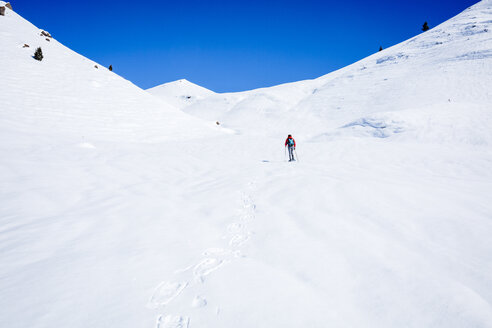 Mid distance view of hiker hiking on snow covered mountain at Joshua Tree National Park - CAVF15326