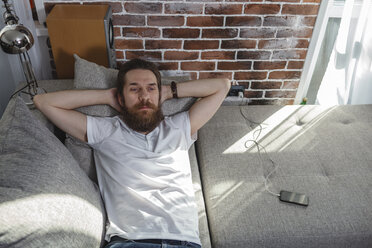 Portrait of bearded man relaxing on the couch at home - VPIF00391