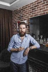 Porträt eines bärtigen Mannes mit einem Glas Whiskey zu Hause - VPIF00392
