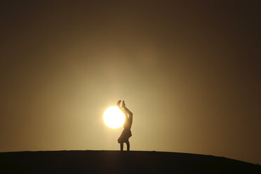 Silhouette Mann macht Handstand auf Feld gegen klaren Himmel bei Sonnenuntergang - CAVF15368