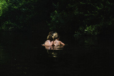 Rear view of family swimming in lake - CAVF15403