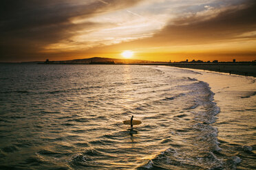 Surfer im Meer am Strand bei Sonnenuntergang - CAVF15427