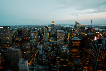 Empire State Building inmitten einer beleuchteten Stadtlandschaft in der Abenddämmerung - CAVF15438