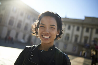Porträt einer lächelnden Frau, die an einem Gebäude in der Stadt steht - CAVF15499