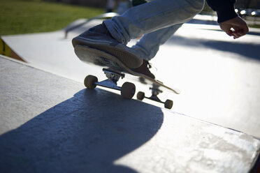 Niedriger Ausschnitt eines Mädchens, das auf einer Sportrampe im Park Skateboard fährt - CAVF15516