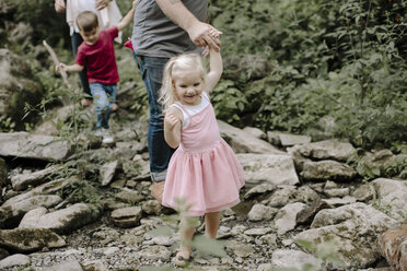 Niedriger Ausschnitt von Eltern, die mit Kindern auf Felsen im Wald spazieren gehen - CAVF15583