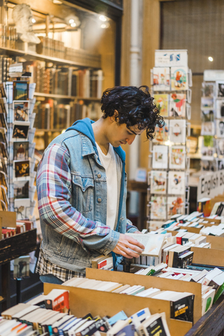 Junger Mann in einer Buchhandlung, lizenzfreies Stockfoto