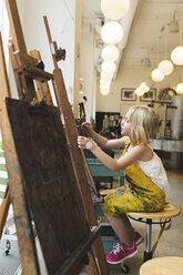 Seitenansicht eines ernsten Mädchens, das zu Hause auf einer Leinwand malt - CAVF15633