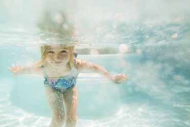 Mädchen schwimmt im Pool an einem sonnigen Tag - CAVF15635