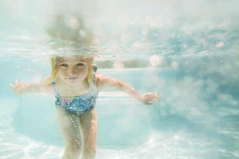 Girl swimming in pool on sunny day - CAVF15635