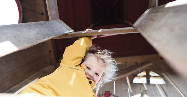 Low angle portrait of happy girl standing by railing at home - CAVF15666