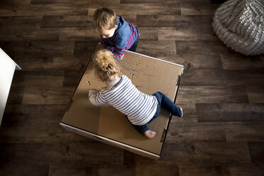 Draufsicht auf Kinder, die zu Hause auf einer Kiste spielen - CAVF15714