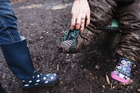 Ausgeschnittenes Bild einer Mutter, die die schmutzige Hose ihres Kindes auf der Rutsche im Park hält - CAVF15730