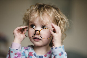 Close-up of girl with eyeglasses at home - CAVF15742