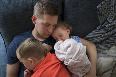Blick von oben auf einen Vater mit Kindern, die zu Hause auf dem Sofa schlafen - CAVF15760