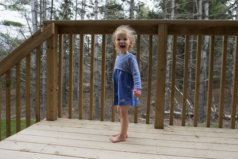 Porträt eines fröhlichen Mädchens, das am Geländer steht - CAVF15761