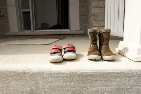 Ein Paar Schuhe auf der Stützmauer vor dem Haus - CAVF15782