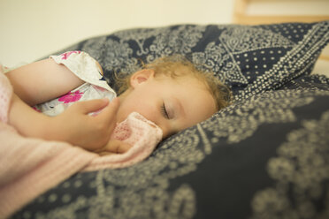 Hohe Winkel Ansicht von Mädchen schlafen mit Decke auf dem Bett zu Hause - CAVF15795