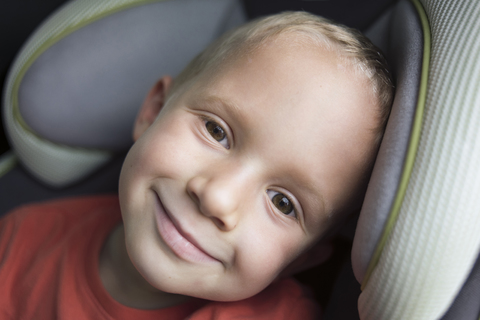 Porträt eines glücklichen Jungen, der in einem Fahrzeug sitzt, lizenzfreies Stockfoto