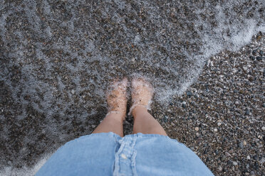 Low section of girl standing on beach in water - CAVF15844