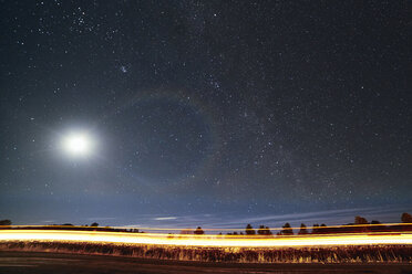 Light trails on road against star field at night - CAVF15856