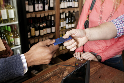 Hoher Blickwinkel des kleinen Geschäftsinhabers, der die Kreditkarte eines Kunden in einem Weinladen entgegennimmt - CAVF15893