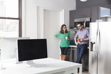 Kreative Geschäftskollegen halten Kaffeebecher, während sie im Büro diskutieren - CAVF15911