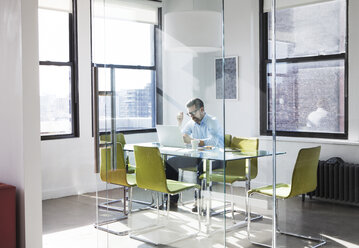 Creative businessman using laptop in board room - CAVF15917