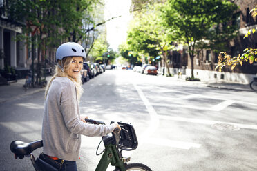 Seitenansicht Porträt einer glücklichen Frau mit Fahrrad auf der Straße - CAVF15954