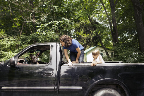 Schwestern sehen sich den Hund im Pick-up-Truck an - CAVF15994