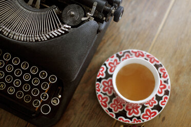 Draufsicht auf Schreibmaschine und Tee auf Holztisch - CAVF16120