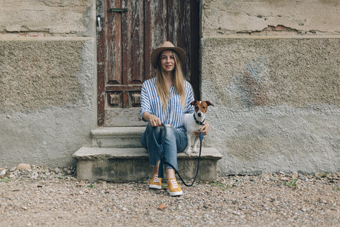 Porträt einer Frau mit Jack Russell Terrier auf einer Treppe sitzend - CAVF16168