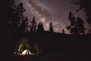 Beleuchtetes Zelt im Wald gegen den nächtlichen Himmel - CAVF16235
