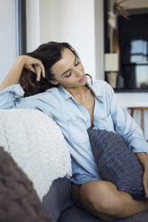 Woman with eyes closed relaxing on sofa - CAVF16321