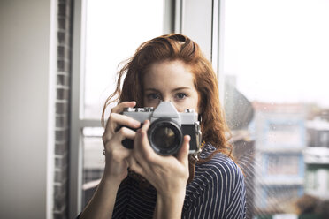 Portrait of woman holding digital camera - CAVF16365