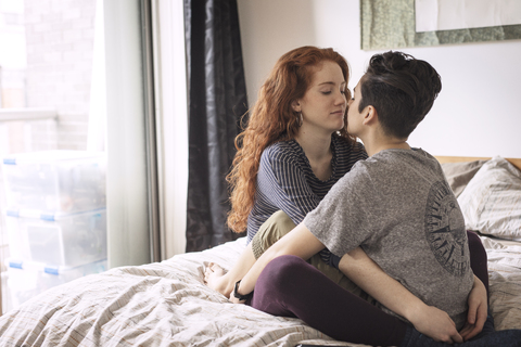 Lesben, die sich zu Hause auf dem Bett entspannen, lizenzfreies Stockfoto