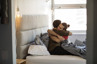 Homosexual couple embracing on bed at home - CAVF16505