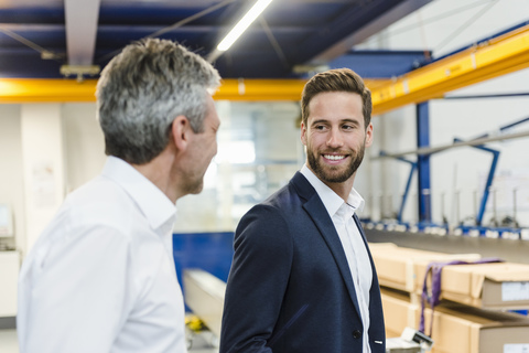 Smiling managers in a production hall stock photo