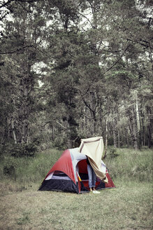 Frau mit Decke vor Zelt gegen Bäume stehend - CAVF16653